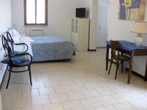 乌尔比诺Country House-B&B-Appartamenti Ai Cipressi的卧室配有一张床和一张桌子及椅子