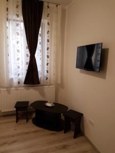 加拉茨Casa Stefan Galati的客厅配有桌子和墙上的电视