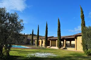 皮恩扎Le Checche的庭院里一座带游泳池和树木的房子