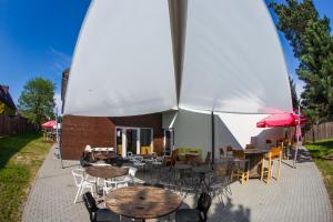 可罗日采特拉佛贝思旅馆的一个带桌椅和遮阳伞的庭院