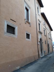 拉奎拉B&B Palazzo Cappa的街道边有两扇窗户的建筑