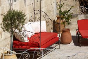 阿维尼翁新城阿特利亚酒店的坐在种有盆栽植物的庭院里的红色长凳