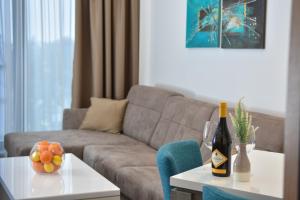 兹拉蒂博尔Alibi Zlatibor Inn的客厅配有沙发和一张桌子及一瓶葡萄酒