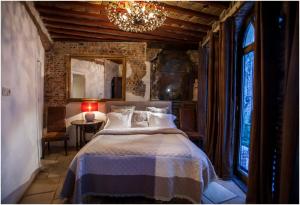 安特卫普三王旅馆的一间卧室配有一张床和一个吊灯