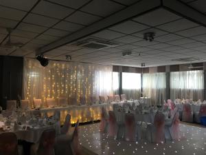 格拉斯哥克罗克斯顿酒店的宴会厅配有白色的桌椅和灯