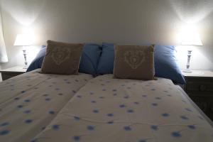达沃斯罗卡贝拉公寓的卧室内的一张带蓝色床单和枕头的床
