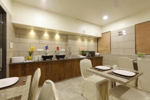 艾哈迈达巴德阿尔卡酒店的厨房配有桌椅和柜台。