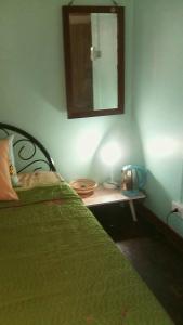 曼谷年轻美丽旅馆的一间卧室配有一张床和一张带镜子的桌子