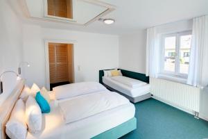 施万高克莱纳康尼格坑酒店的一间白色卧室,配有两张床和窗户