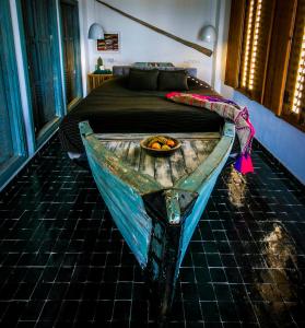 塔哈佐特Munga Guesthouse的卧室里的旧木船,带床