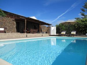 蒂亚斯El Cercado的一座大蓝色游泳池,位于房子前
