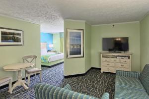 特拉弗斯城苏格海滩度假村酒店的酒店客房设有床、桌子和电视。