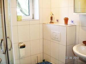 卡尔斯哈根FH Charlottchen_WEIG的白色瓷砖浴室设有水槽和淋浴