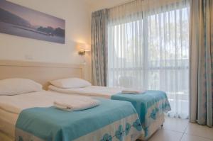 亚实基伦里贾纳格伦酒店的酒店客房设有两张床和窗户。