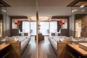 卡尔达罗Das Panorama Designhotel的酒店客房,设有两张床和镜子