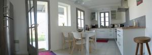 雷岛林滩269 Bel Ebat的厨房配有白色橱柜和桌椅