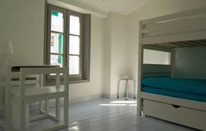 雷岛林滩269 Bel Ebat的一间卧室配有双层床、书桌和窗户。