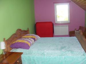 Kolonia PohulankaPohulanka - Białowieża的一间卧室配有一张床和一张红色椅子