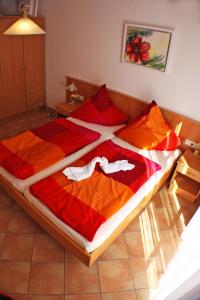特龙扎诺拉戈马焦雷Case Bellissime的一间卧室配有一张大床,提供红色和橙色的毯子