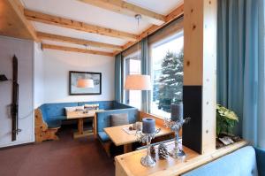 达沃斯康坎迪亚酒店的客厅配有蓝色的沙发和桌子
