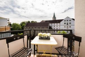 帕德博恩Hotel zur Mühle的一个带桌椅的阳台和一个教堂