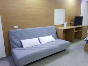 迈季代勒舍姆斯סנו נופש בגולן的客房内的蓝色沙发,配有2个白色枕头