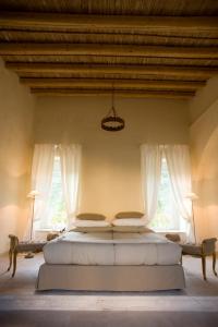 Vizzini卡斯特罗卡米尼旅馆的一间卧室设有一张大床和两个窗户