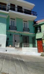 瓦尔帕莱索Casa Mackenna的绿色和白色的建筑,有红色的门