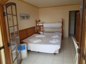 卡纳内亚Pousada Recanto do Morro的一间卧室设有两张双层床和一张桌子