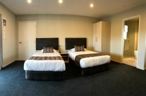 奥克兰艾勒斯利棕榈汽车旅馆的一间酒店客房,房间内设有两张床