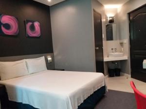 马尼拉Leez Inn Malate的酒店客房设有床和水槽