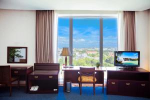 邦美蜀达克若珂酒店的酒店客房设有一张书桌和一个大窗户。