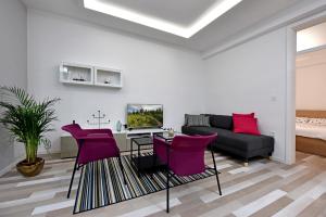 卢布尔雅那Apartment Tivoli Park的客厅配有紫色椅子和沙发