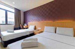 普崇招牌酒店@蒲种瑟迪亚步行区的酒店客房,配有两张床和椅子