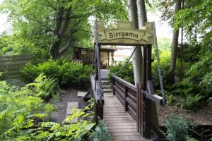 Bad Bodenteich祖姆阿尔腾里特餐厅酒店的花园中带有标志的木桥