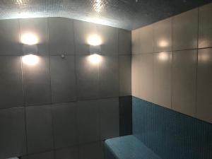 拉夫堡Loughborough Grange Guesthouse & Spa的浴室的墙壁上设有两盏灯,配有长凳
