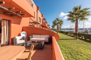 波尔蒂芒Luxury Apartment, Marina, Beach & Pool的一个带桌椅和棕榈树的庭院