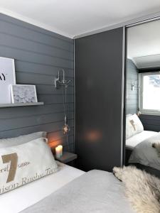 海姆瑟达尔Storehorn Apartments的卧室设有2张床,卧室设有灰色的墙壁