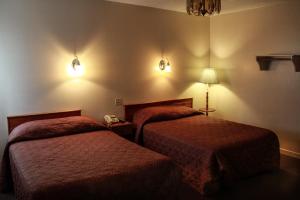 格雷斯港格雷斯港酒店的两张床铺,位于酒店客房,墙上有灯