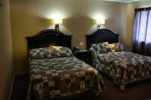 格雷斯港格雷斯港酒店的一间卧室设有两张床,墙上有两盏灯。