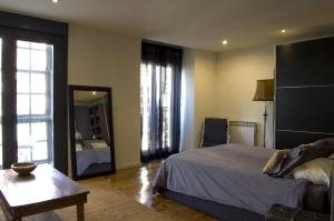 维多利亚-加斯特伊兹Apartamentos Ondoloin的一间卧室配有一张床、一张桌子和一面镜子