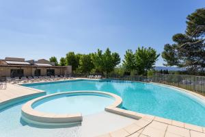 索马讷-德沃克吕兹Madame Vacances Domaine du Provence Country Club Service Premium的周围设有大型游泳池,配有椅子