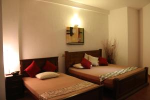 拉维尼亚山Colombo Mount Beach的宿舍间内的两张床,配有红色枕头