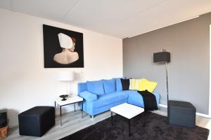 栋堡Roosjesweg 1a的客厅配有蓝色沙发和绘画作品