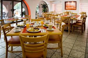 韦拉克鲁斯韦拉克鲁斯历史中心酒店的一间餐厅配有桌椅,提供食物