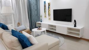 普拉亚Elegant Modern Blue Apartment的客厅配有白色沙发和电视