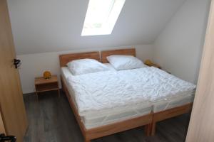 MinsenFerienwohnungen Hensel的一间卧室配有一张带白色床单的床和一扇窗户。