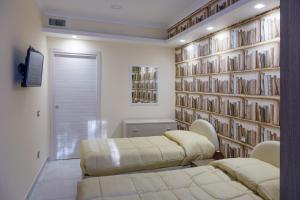 维克艾库塞Casa Micla的一间设有两张床和一堵书墙的房间