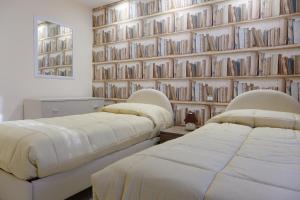 维克艾库塞Casa Micla的配有两张床铺的带书墙的房间