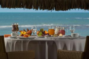 福廷Vila Selvagem Hotel Contemporaneo的一张桌子,上面有水果和果汁,后面有大海